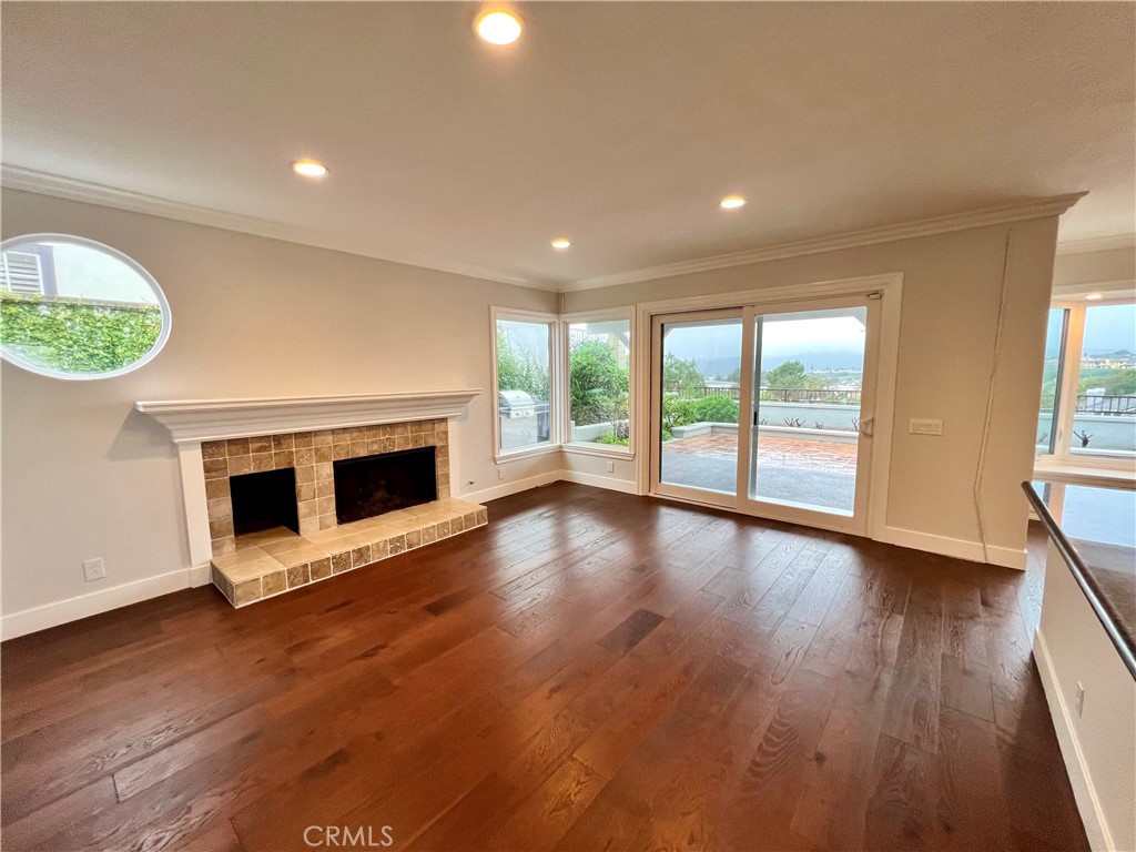 15 Larkfield Lane Laguna Niguel, CA 92677 - Photo 14 of 55 an empty room with wooden floor fireplace and windows