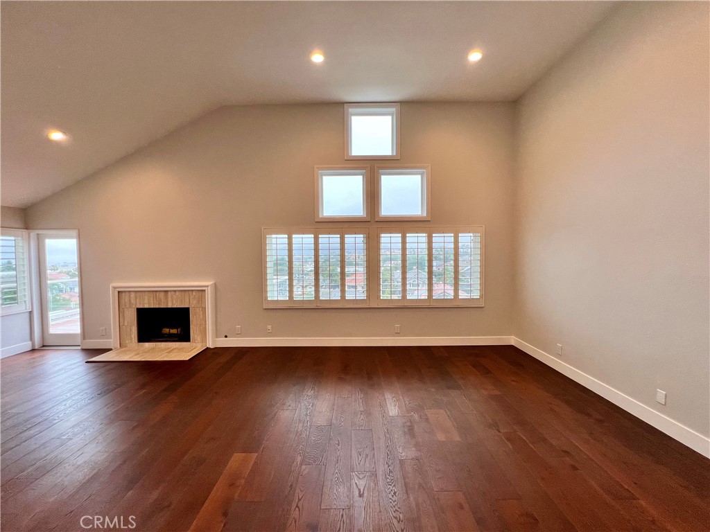 15 Larkfield Lane Laguna Niguel, CA 92677 - Photo 35 of 55 an empty room with wooden floor a fireplace and windows