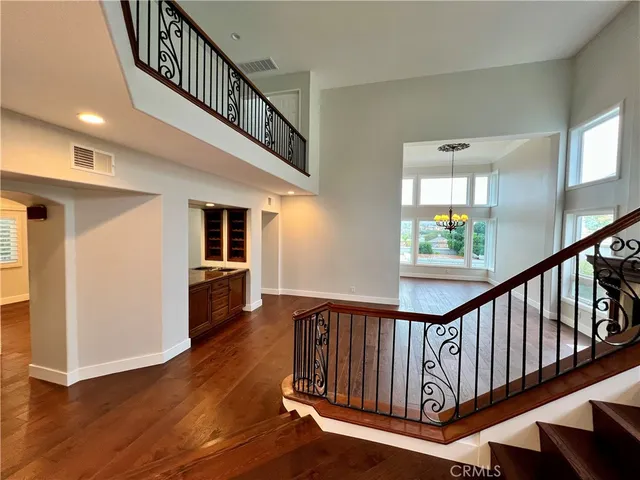 a view of staircase with lots of frames on wall and a window