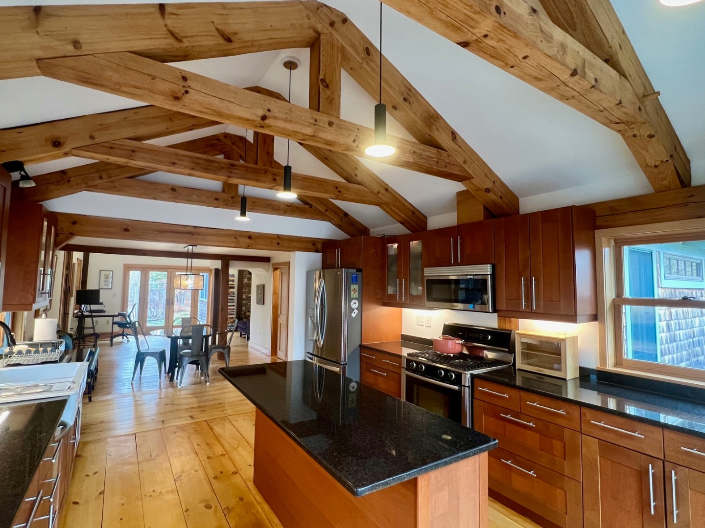 50 Bradley Martin Road West Tisbury, MA 02568 - Photo 2 of 37 a kitchen with stainless steel appliances granite countertop a stove top oven a sink a dining table and chairs with wooden floor