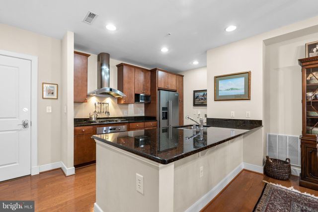 a large kitchen with stainless steel appliances granite countertop a sink a stove and a refrigerator