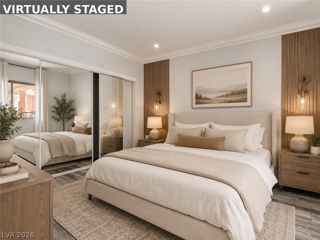 260 East Flamingo Road, Unit 220 Las Vegas, NV 89169 - Photo 31 of 32 An inviting bedroom with mirrored closet doors and warm wall sconces creates a serene retreat.