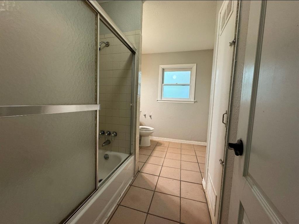 514 Woodrow Avenue Fort Worth, TX 76105 - Photo 13 of 13 a bathroom with a glass shower door