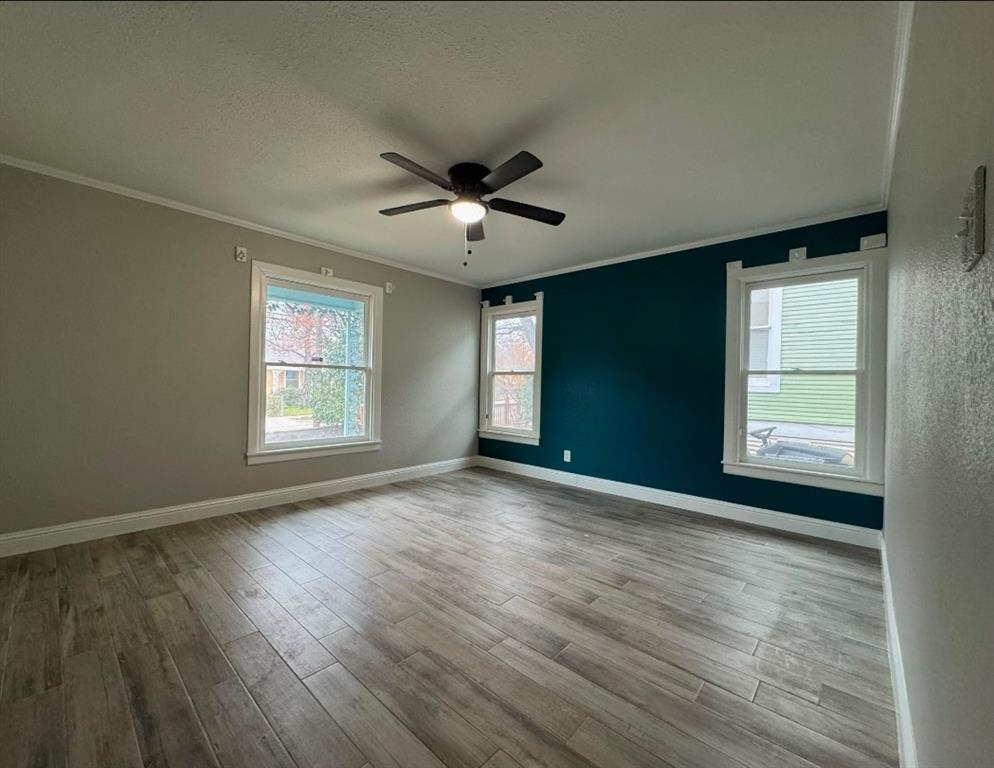 514 Woodrow Avenue Fort Worth, TX 76105 - Photo 3 of 13 an empty room with wooden floor and windows