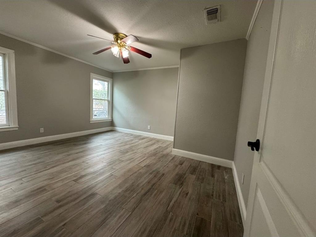 514 Woodrow Avenue Fort Worth, TX 76105 - Photo 4 of 13 wooden floor in an empty room with a window