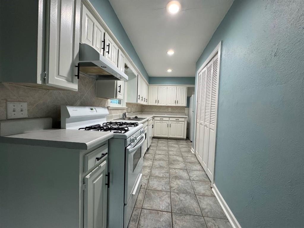 514 Woodrow Avenue Fort Worth, TX 76105 - Photo 5 of 13 a kitchen with stainless steel appliances granite countertop a stove and a sink