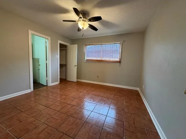 an empty room with fan and windows
