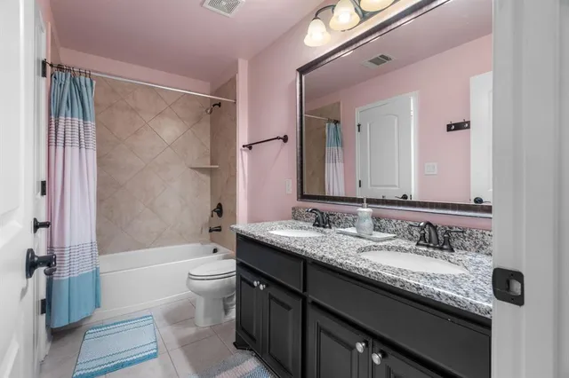 a bathroom with a granite countertop sink a toilet a mirror a bathtub and shower