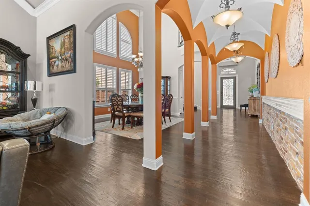 a dining hall with couches a dining table and chairs with wooden floor