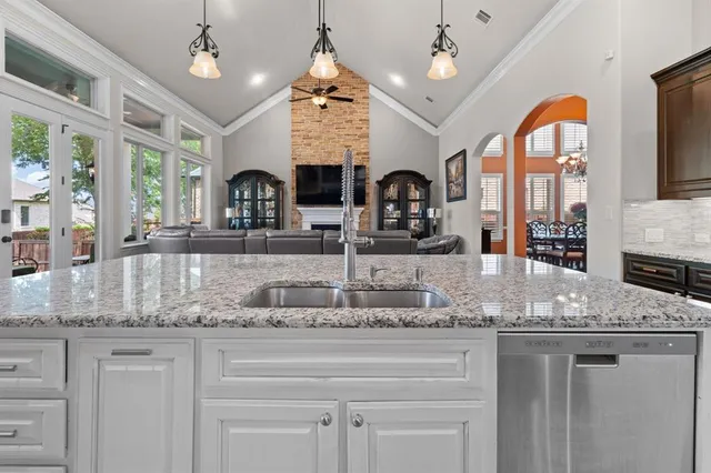 a kitchen with center island a large counter top space cabinets and stainless steel appliances