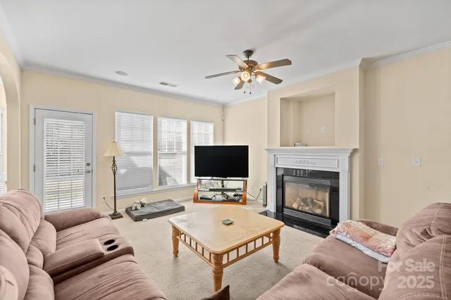a living room with furniture a fireplace and a flat screen tv