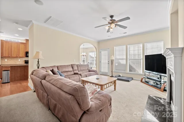 a living room with furniture a flat screen tv and a large window