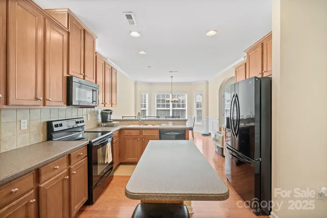 a kitchen with stainless steel appliances granite countertop a refrigerator stove microwave and sink