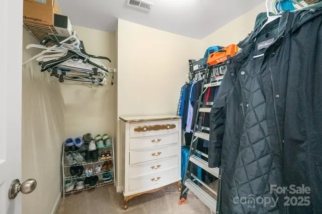 a view of walk in closet with clothes and shoes