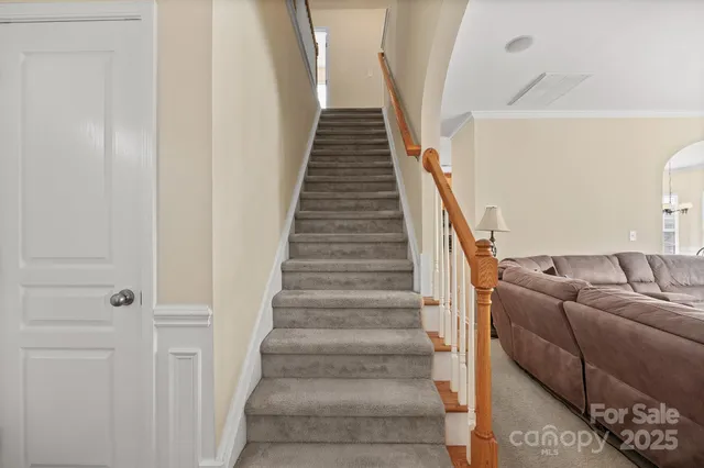 a living room with furniture and a stairs