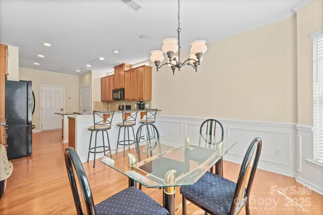 a view of a dining room with furniture a chandelier and wooden floor