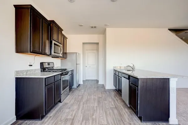 a kitchen with granite countertop a sink and a stove top oven