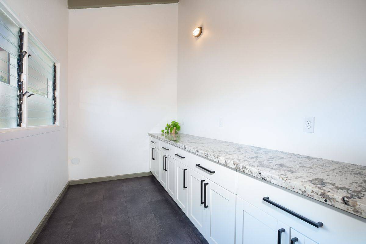 68-1788 Auhili Loop Waikoloa, HI 96738 - Photo 20 of 29 a hallway with granite countertop white cabinets and a granite floor