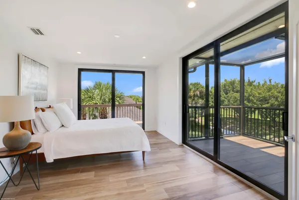 a bedroom with a bed and a large window