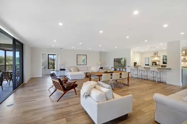 a living room with furniture wooden floor and a kitchen view