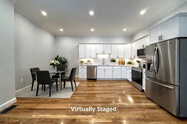 a kitchen with refrigerator and chairs