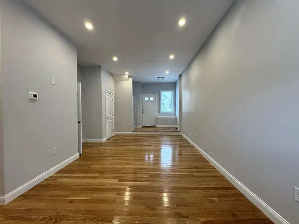 a view of an empty room with wooden floor