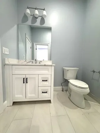 a spacious bathroom with a toilet sink and mirror