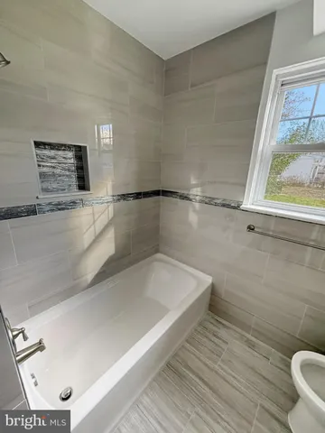 a bathroom with a bathtub and a window