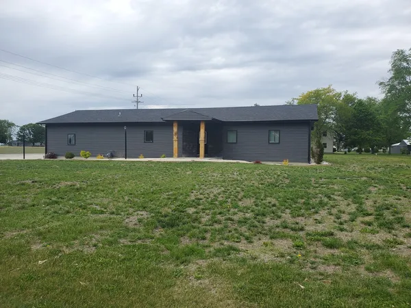 a view of a brick house next to a big yard