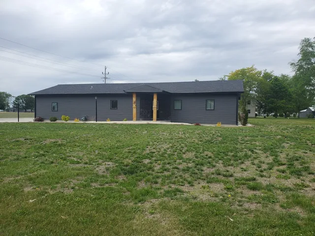 a view of a brick house next to a big yard