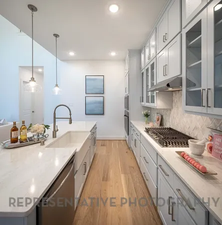 a large kitchen with stainless steel appliances a sink a stove and cabinets