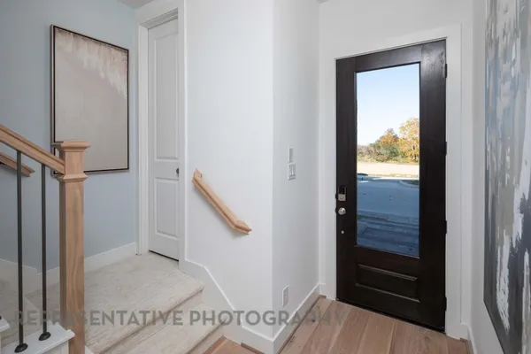 a view of a hallway with wooden floor and entryway