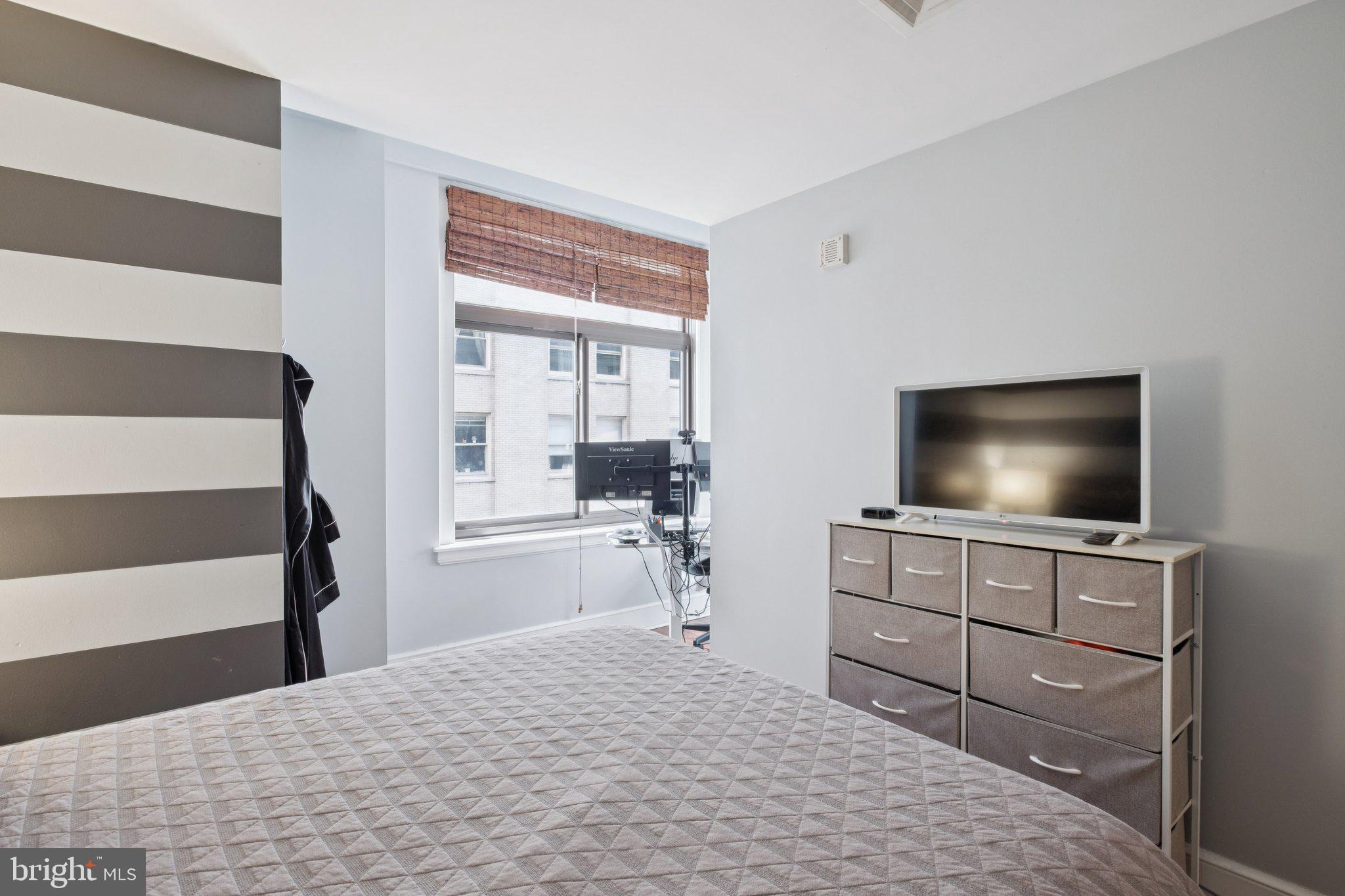 1500 Chestnut Street, Unit 15E Philadelphia, PA 19102 - Photo 3 of 5 a bedroom with a bed and a flat screen tv