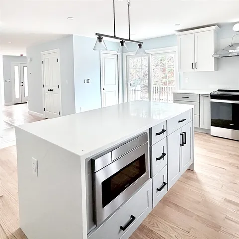 a kitchen with granite countertop white cabinets and white appliances