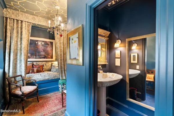 a bathroom with a granite countertop sink and a large mirror next to a window