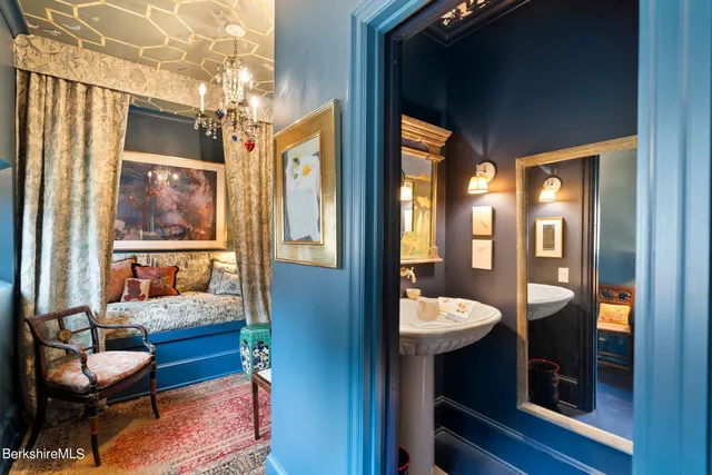 a bathroom with a granite countertop sink and a large mirror next to a window