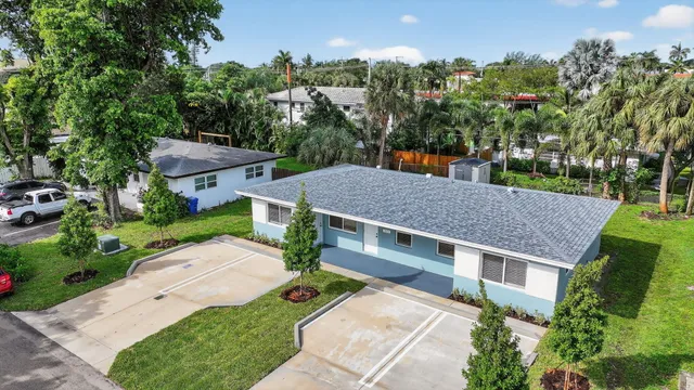 an aerial view of a house with swimming pool and a yard