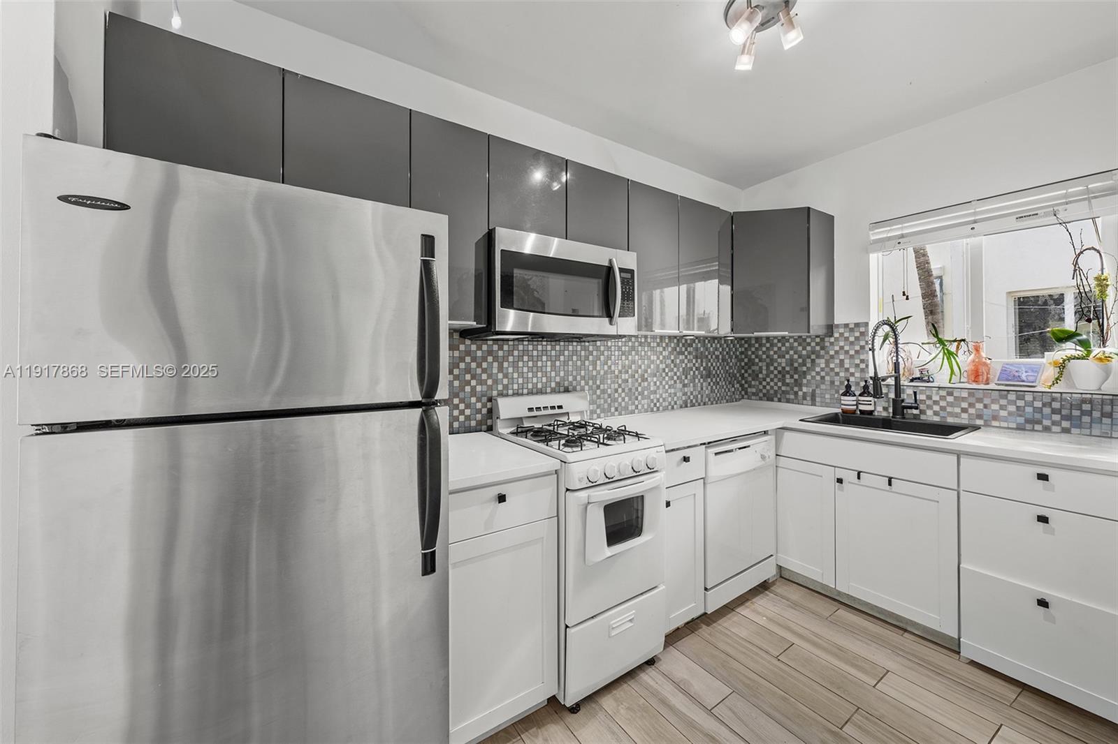 1120 Venetian Way, Unit 1D Miami, FL 33139 - Photo 5 of 11 a white refrigerator freezer sitting inside of a kitchen