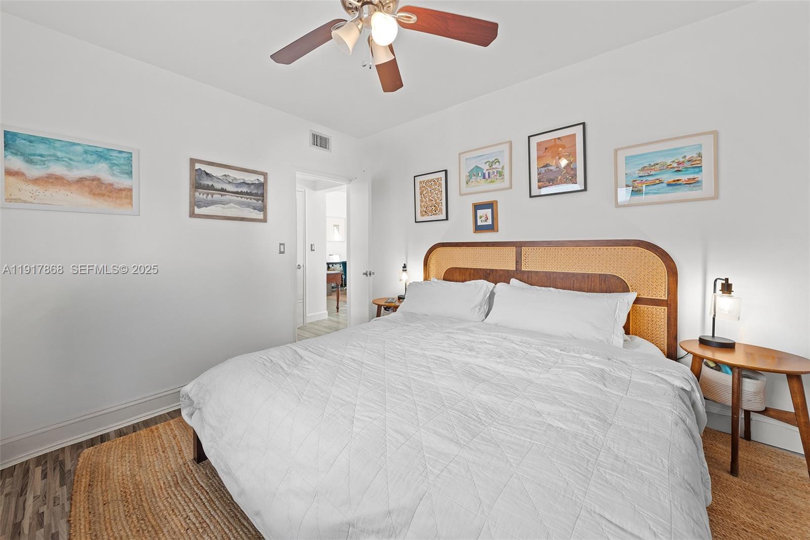 1120 Venetian Way, Unit 1D Miami, FL 33139 - Photo 6 of 11 a bedroom with a bed and wooden floor