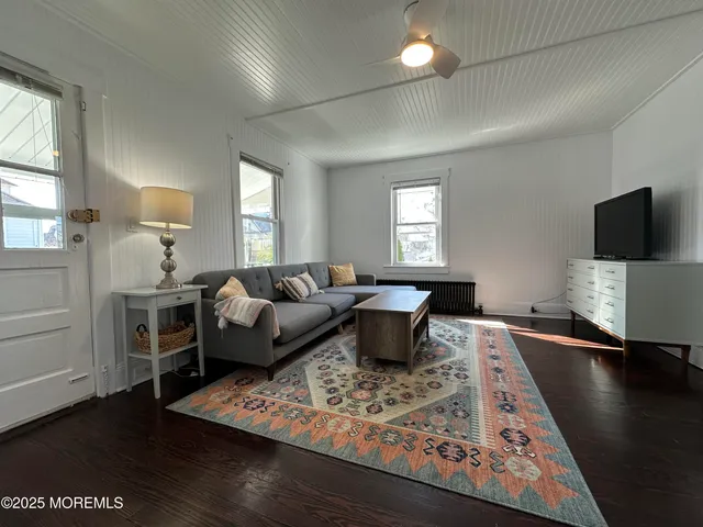 a living room with furniture a flat screen tv and a window