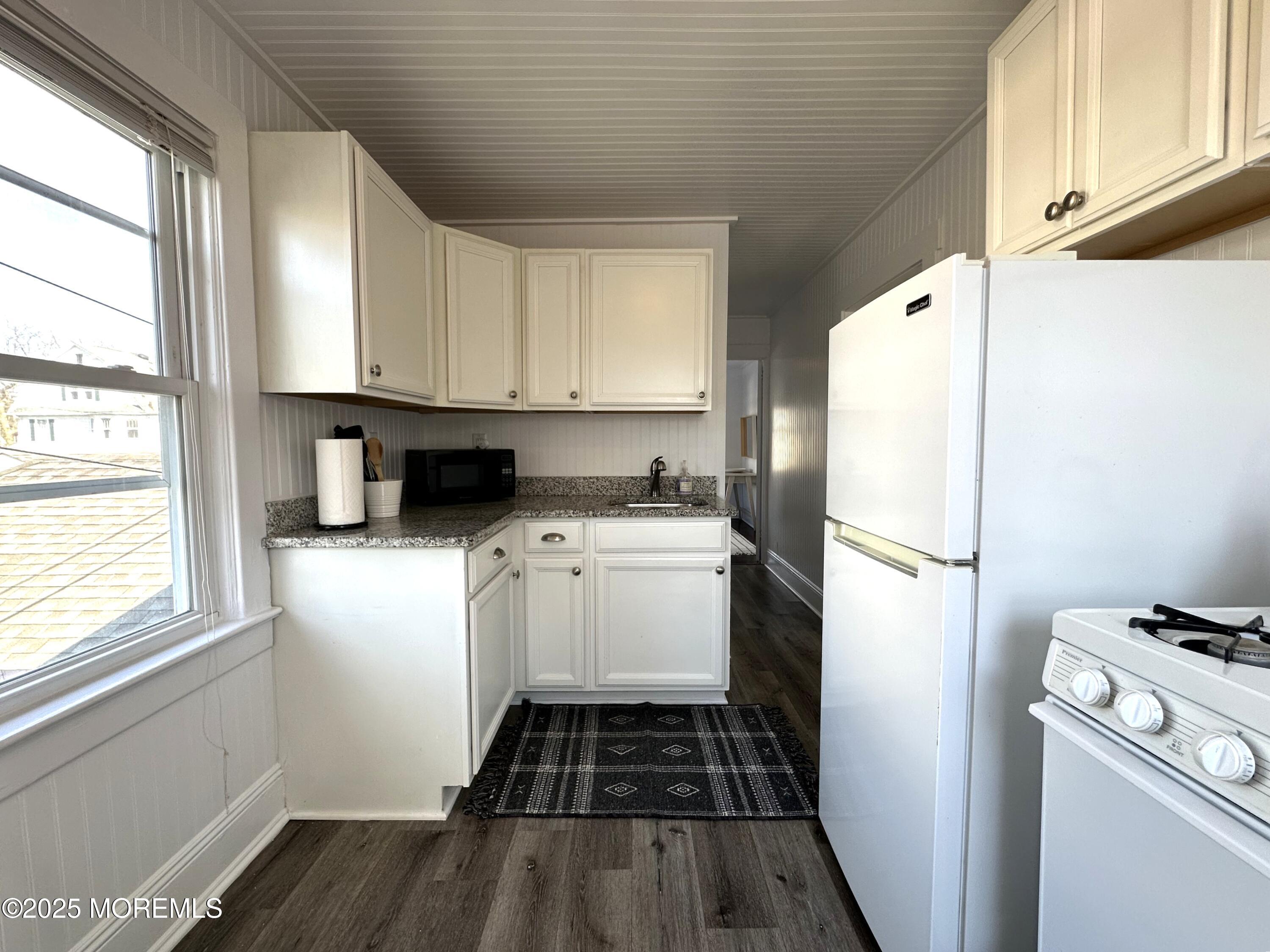 506 7th Avenue, Unit REAR Belmar, NJ 07719 - Photo 7 of 16 a kitchen with a refrigerator and a stove