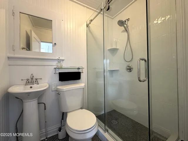 a bathroom with a toilet sink shower and mirror