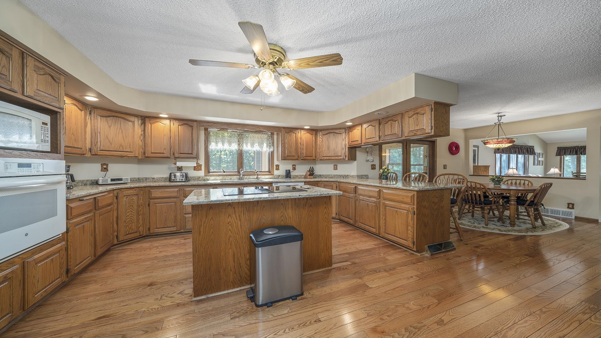 5221 West Edgewood Road Dixon, IL 61021 - Photo 4 of 43 a kitchen with stainless steel appliances granite countertop wooden floors and white cabinets