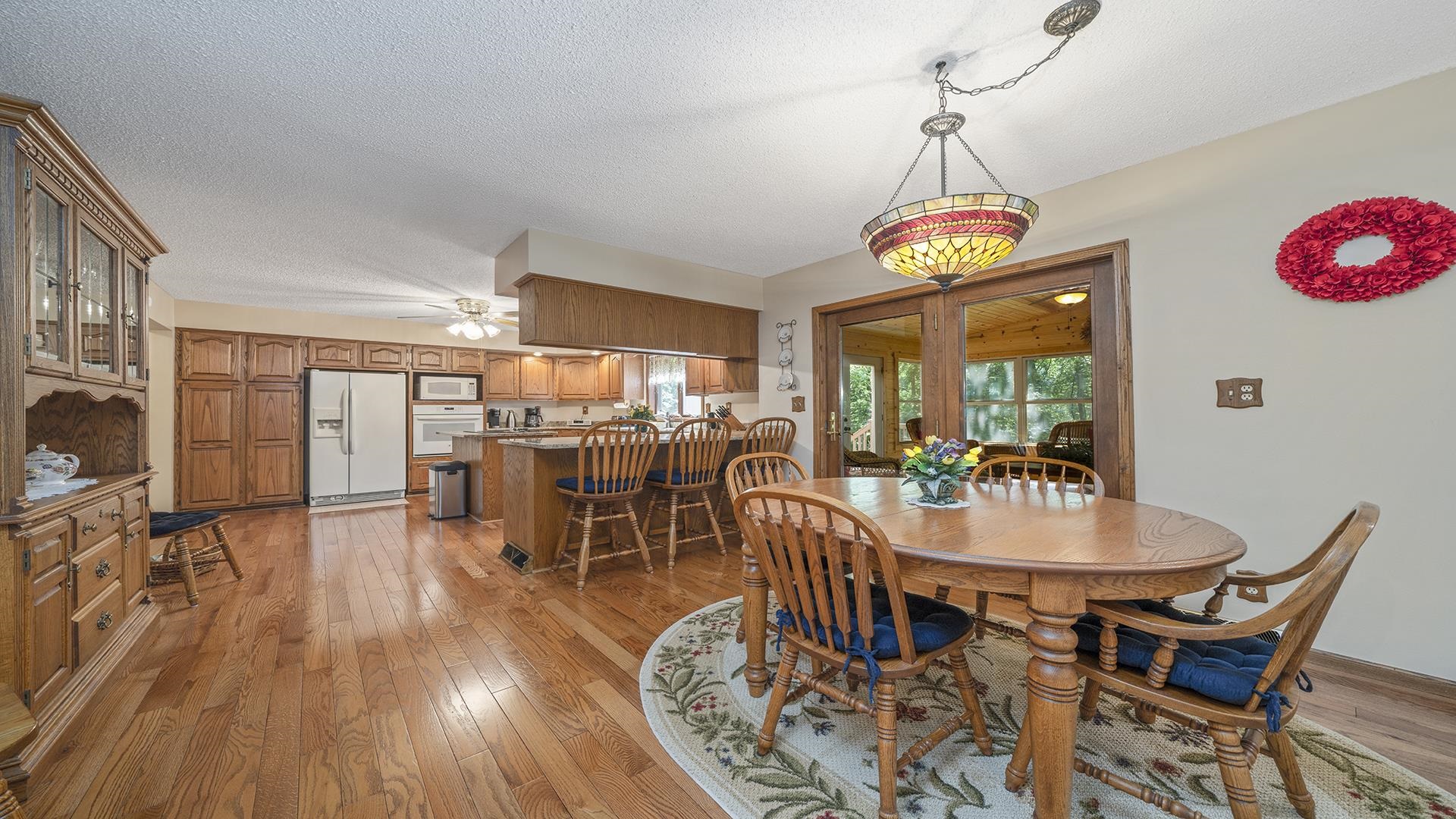 5221 West Edgewood Road Dixon, IL 61021 - Photo 9 of 43 a dining room with wooden floor a chandelier a wooden table and chairs