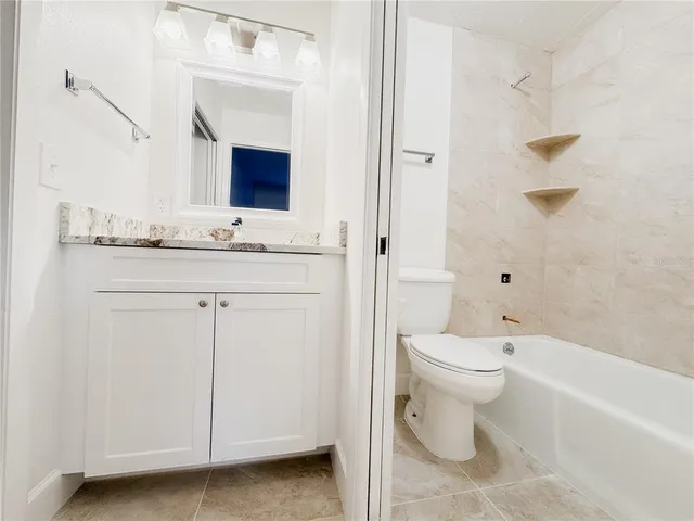 a bathroom with a toilet a sink a vanity and mirror