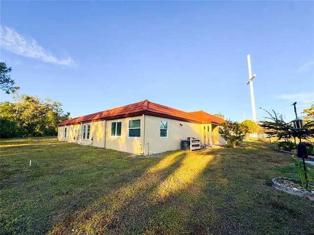 a view of a house with a small yard and potted plants