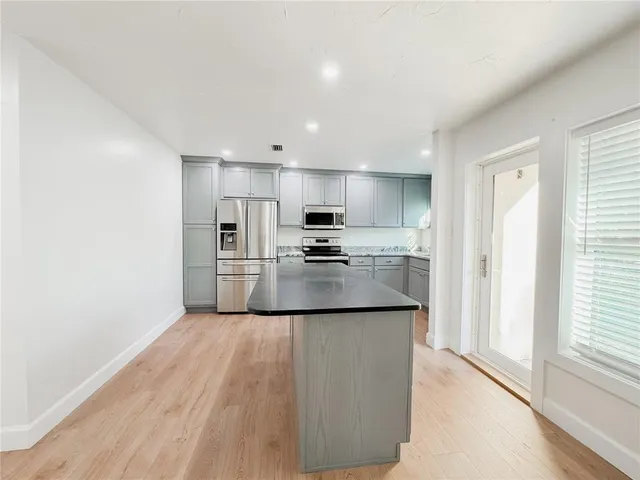 a kitchen with stainless steel appliances granite countertop a refrigerator and a stove top oven