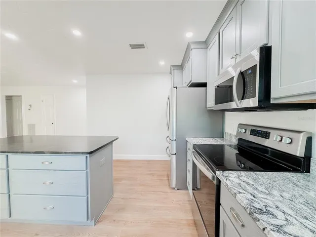 a kitchen with stainless steel appliances granite countertop a sink and a stove