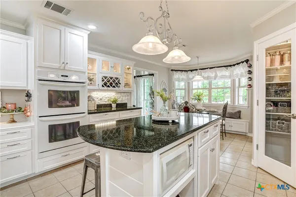 a kitchen with stainless steel appliances granite countertop a sink a stove counter space and cabinets