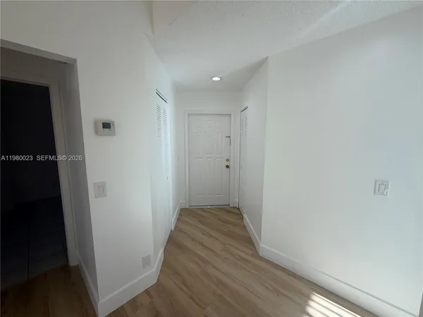 a view of a hallway with wooden floor